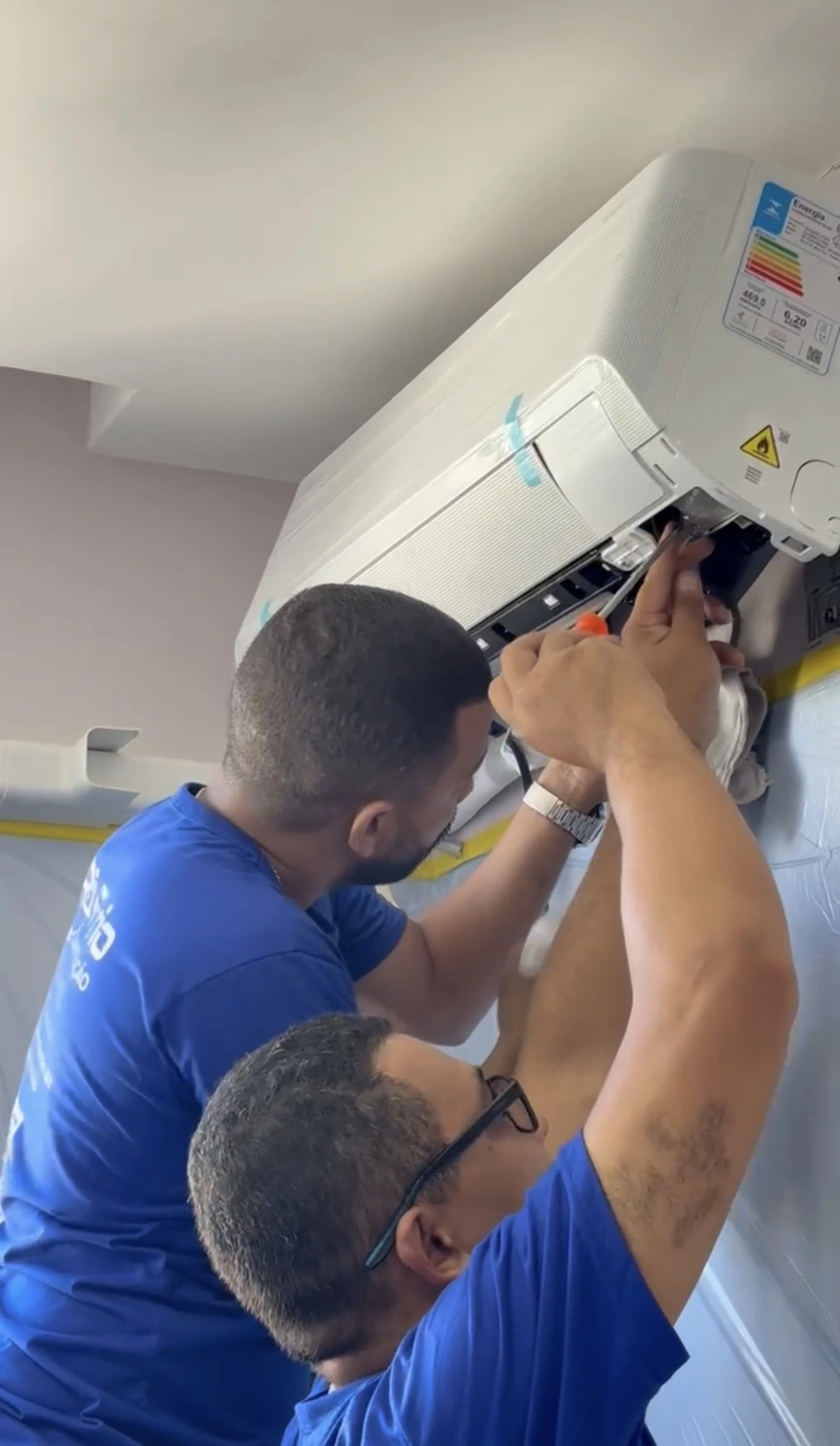 Técnico instalando ar-condicionado split em apartamento moderno